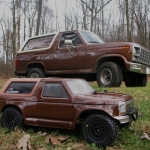 <strong class='magnific-title'>Scruff McGruff</strong> 2wd Slash, with Pro-Line 81 Ford Bronco Body. Supported by Pro-Line Extended Body Mounts. Bronco is sitting on Pro-Line Renegade wheels wrapped in Pro-Line Badlands SC tires. Behind it sits my 1980 Bronco.